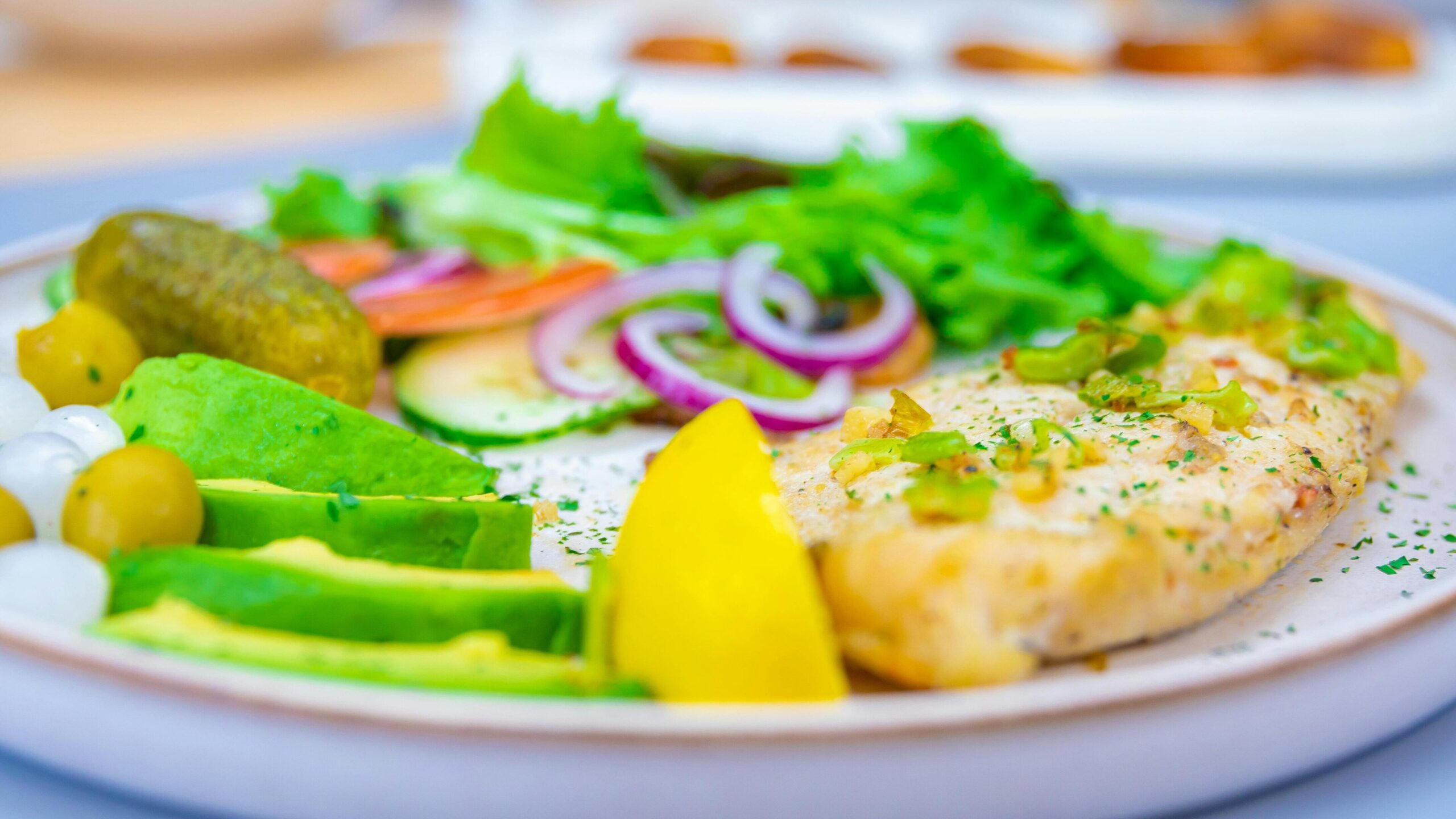 Vibrant dish featuring fresh salad, fish fillet, and assorted vegetables served indoors.